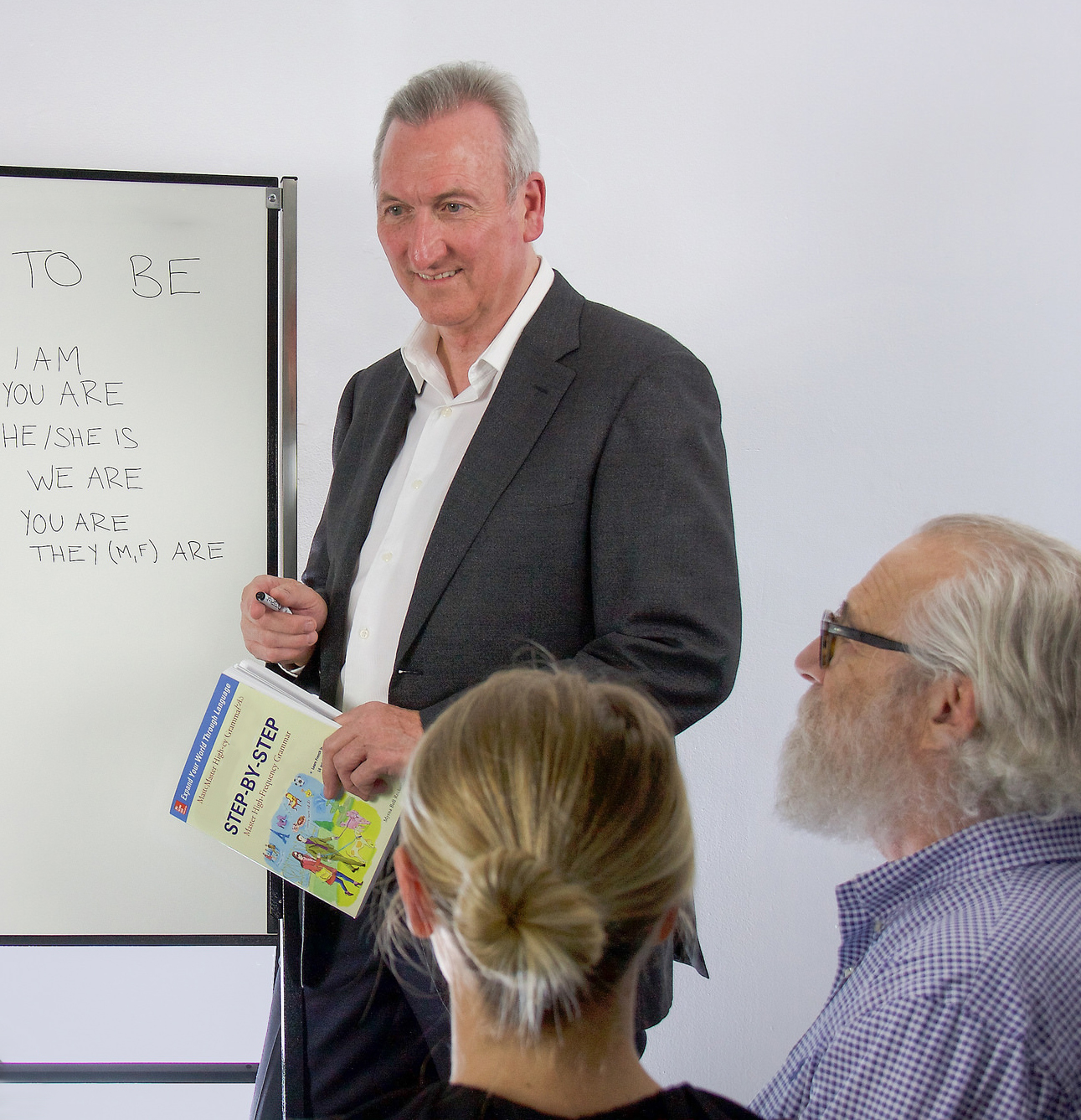 Mike standing in front of a class giving an English lesson